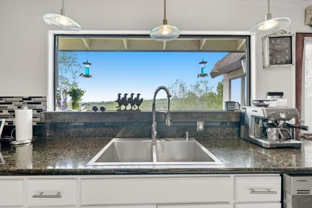 a kitchen with kitchen island a sink stainless steel appliances and a counter top space