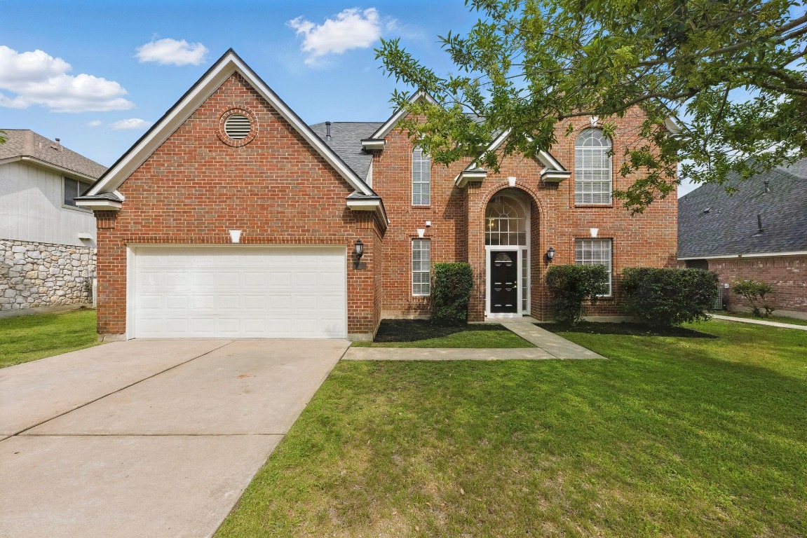 a front view of a house with a yard and garage