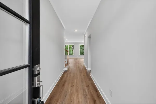 a view of a hallway with wooden floor