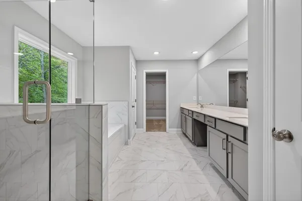 a bathroom with a tub sink and mirror