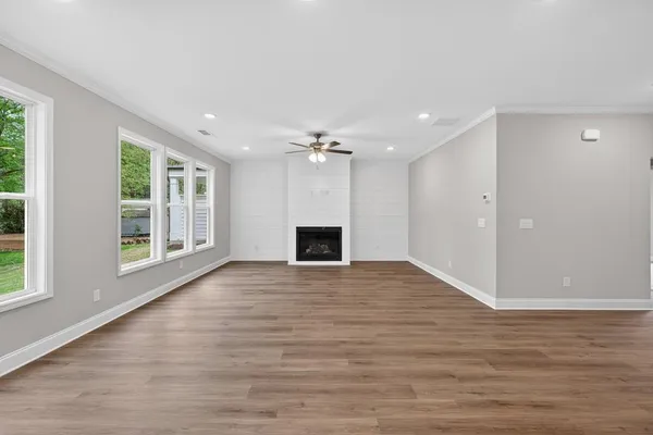 a view of an empty room with a window and fireplace
