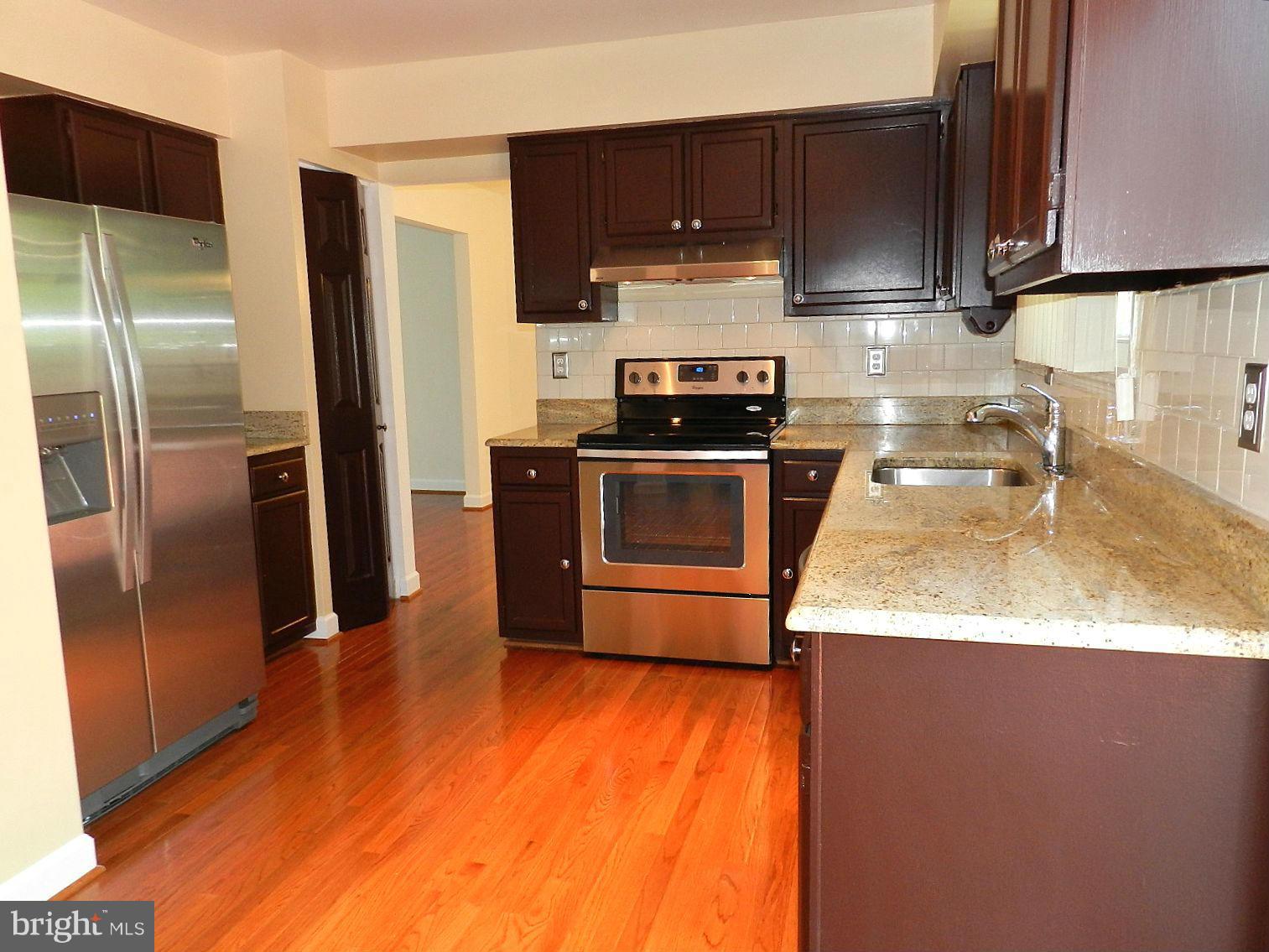 932 Pointer Ridge Drive Gaithersburg, MD 20878 - Photo 8 of 29 a kitchen with a sink a refrigerator and a stove top oven