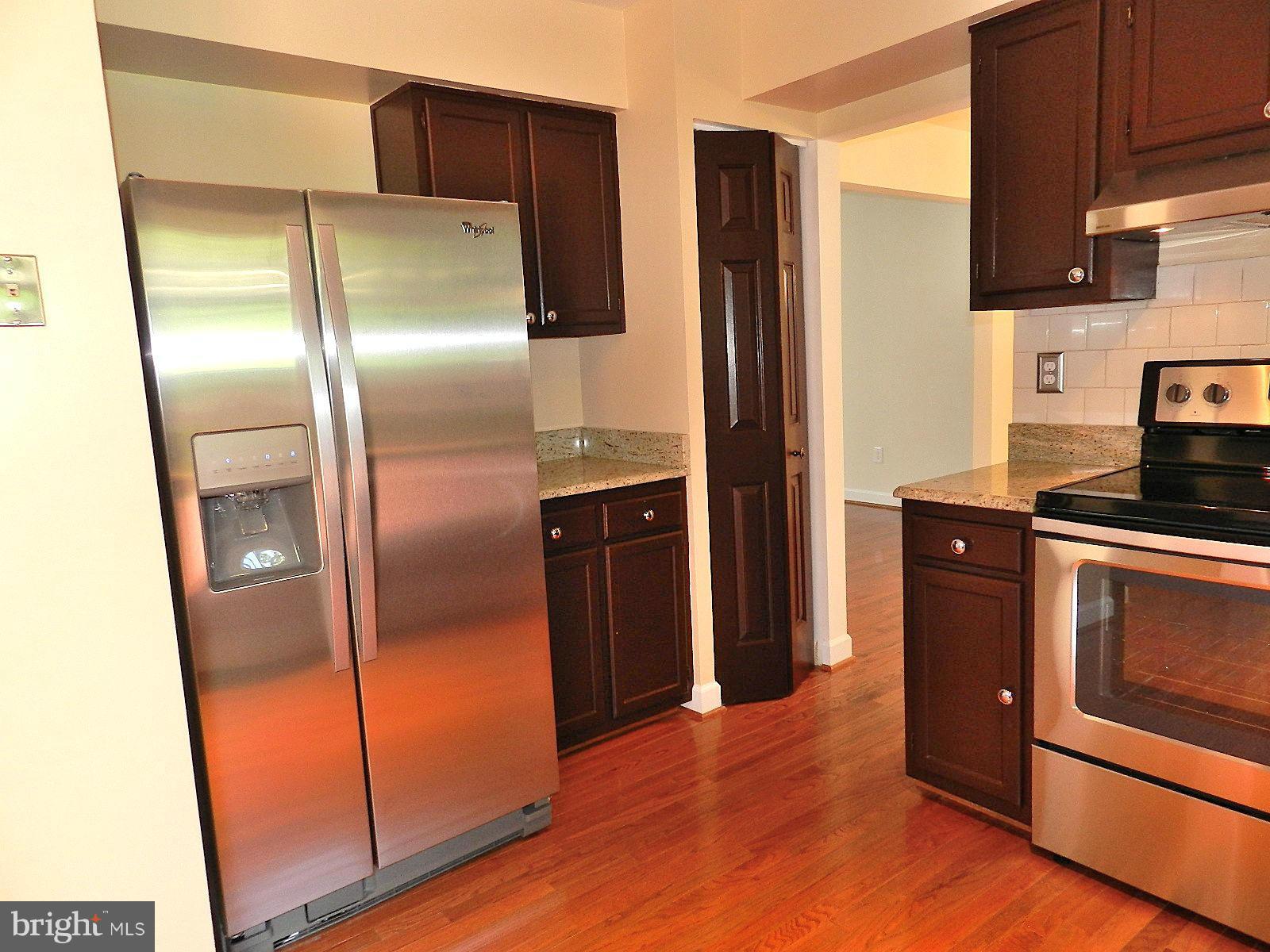 932 Pointer Ridge Drive Gaithersburg, MD 20878 - Photo 9 of 29 a kitchen with stainless steel appliances granite countertop a refrigerator and a sink