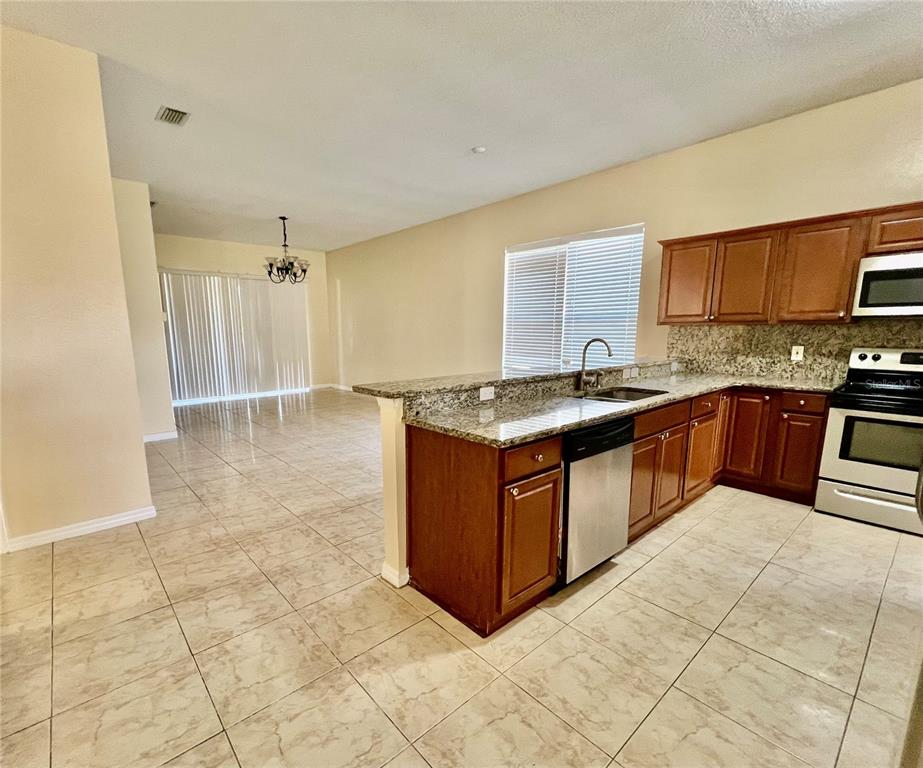 13367 Luxbury Loop Orlando, FL 32837 - Photo 20 of 49 a kitchen with stainless steel appliances granite countertop a sink and a stove