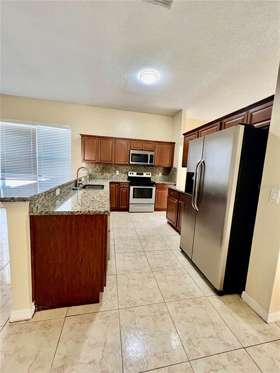 13367 Luxbury Loop Orlando, FL 32837 - Photo 21 of 49 a kitchen with stainless steel appliances granite countertop a refrigerator a stove and a sink