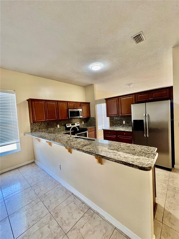 13367 Luxbury Loop Orlando, FL 32837 - Photo 24 of 49 a large kitchen with kitchen island granite countertop a sink and white cabinets