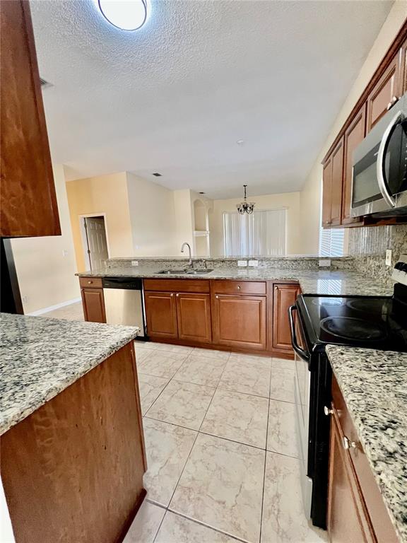 13367 Luxbury Loop Orlando, FL 32837 - Photo 25 of 49 a kitchen with stainless steel appliances granite countertop a sink stove and refrigerator