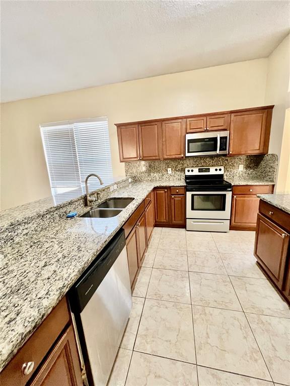 13367 Luxbury Loop Orlando, FL 32837 - Photo 26 of 49 a kitchen with stainless steel appliances granite countertop a sink stove and microwave