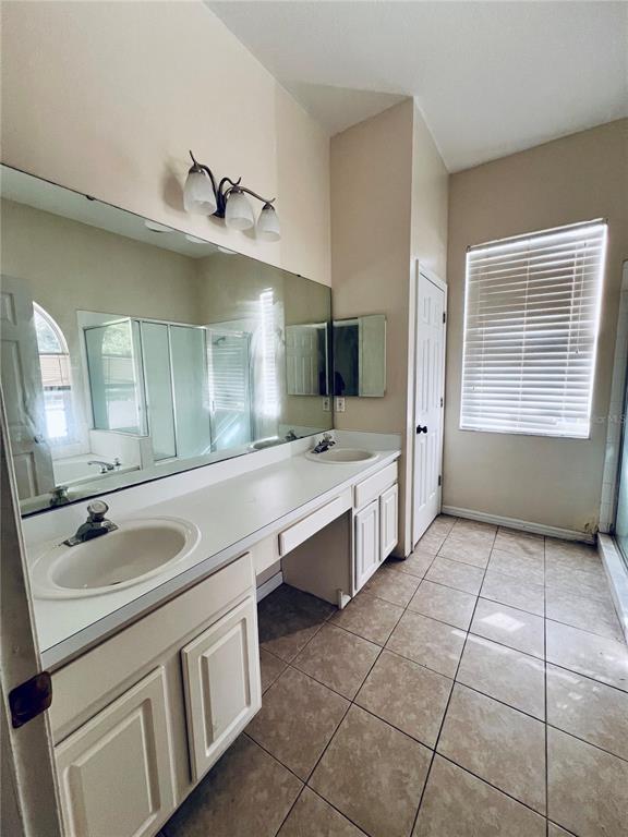 13367 Luxbury Loop Orlando, FL 32837 - Photo 33 of 49 a bathroom with a sink a vanity a mirror and a bathtub