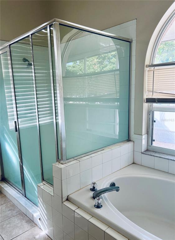 13367 Luxbury Loop Orlando, FL 32837 - Photo 36 of 49 a bathroom with a bathtub and a shower