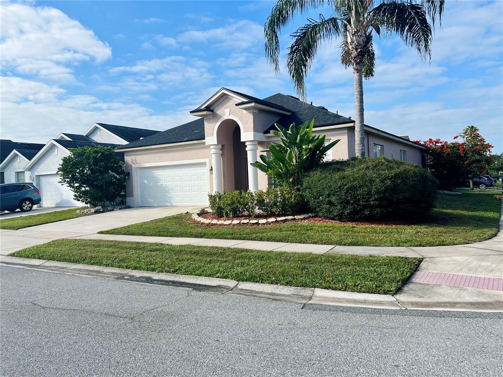 13367 Luxbury Loop Orlando, FL 32837 - Photo 4 of 49 a front view of a house with a garden and trees