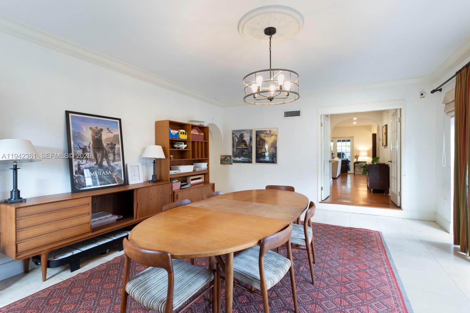 360 Southwest 28th Road Miami, FL 33129 - Photo 11 of 31 a dining room with wooden floor a chandelier a wooden table and chairs