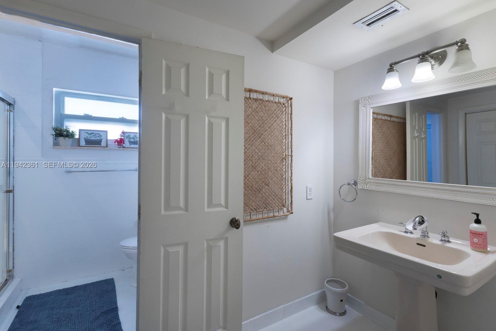 360 Southwest 28th Road Miami, FL 33129 - Photo 18 of 41 a bathroom with a sink a toilet and mirror