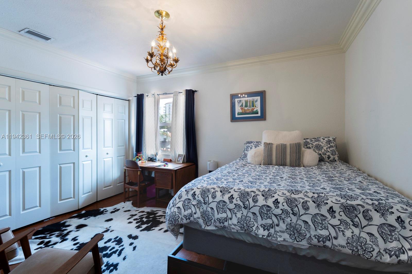 360 Southwest 28th Road Miami, FL 33129 - Photo 19 of 31 a bedroom with a bed and a chandelier