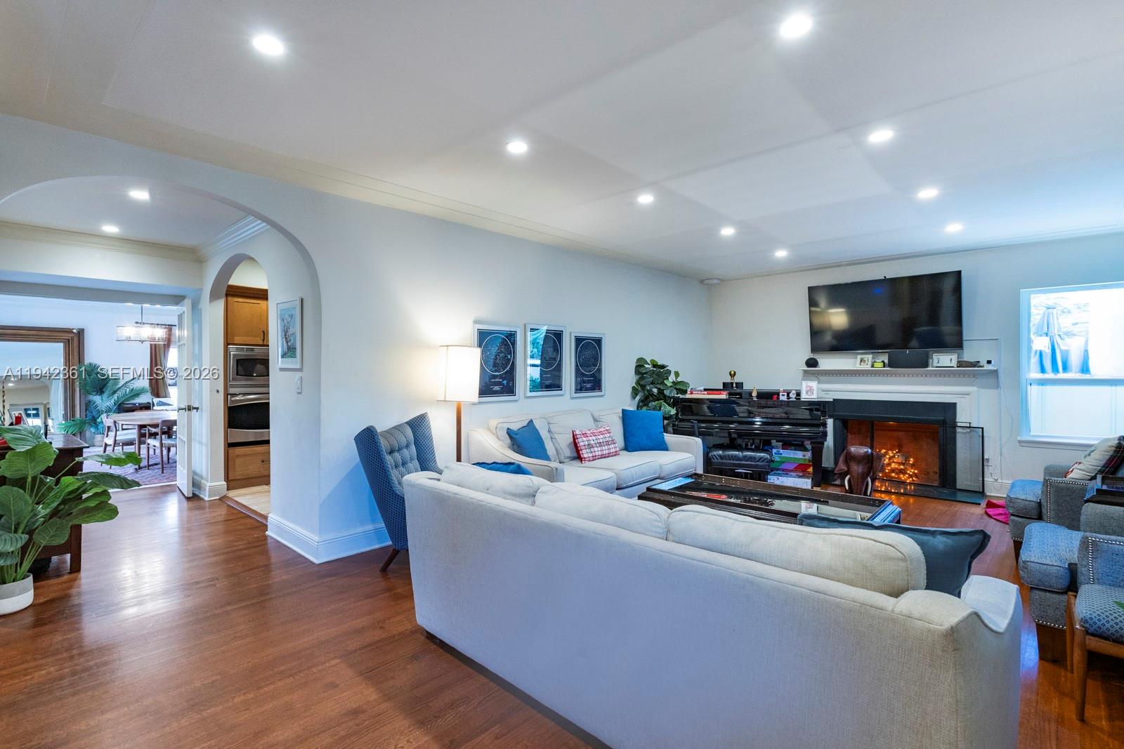 360 Southwest 28th Road Miami, FL 33129 - Photo 2 of 41 a living room with furniture a fireplace and a flat screen tv