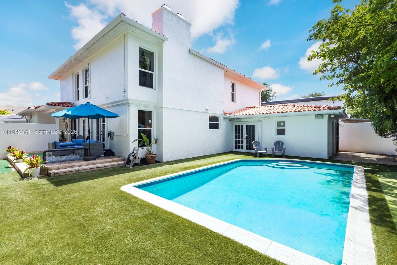 360 Southwest 28th Road Miami, FL 33129 - Photo 5 of 41 a view of a house with pool and chairs under an umbrella