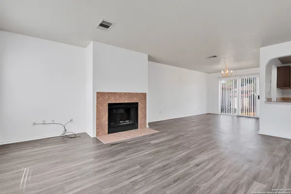 a view of a livingroom with wooden floor and a fireplace