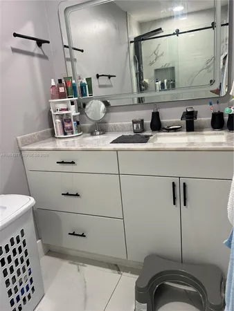 a bathroom with a sink a mirror and shower