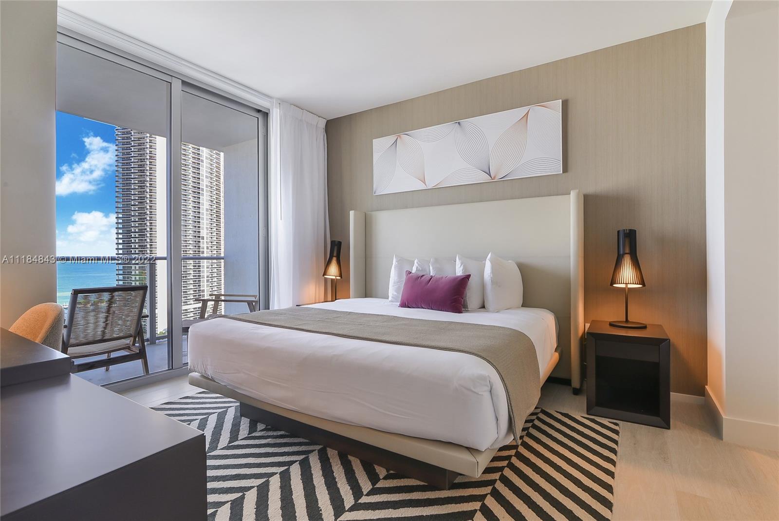 4010 South Ocean Drive, Unit R1405 Hollywood, FL 33019 - Photo 8 of 67 a bedroom with a bed a mirror and a lamp on dresser