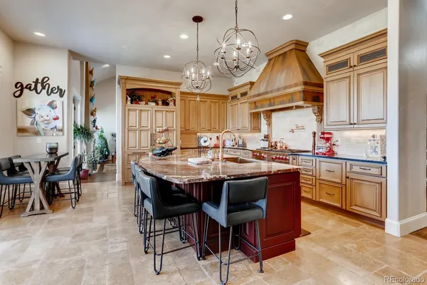 a kitchen with kitchen island granite countertop a sink and a refrigerator