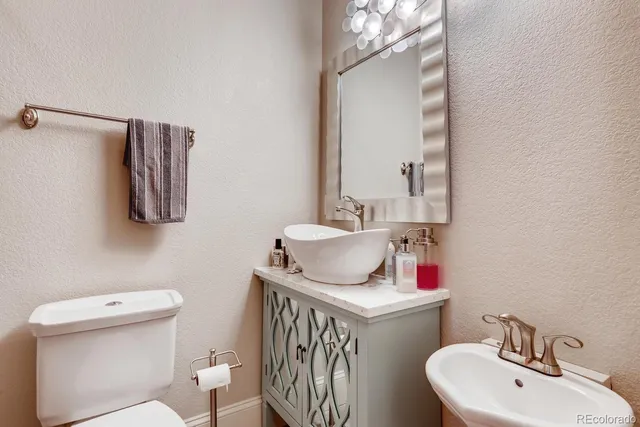 a bathroom with a granite countertop sink a mirror and vanity