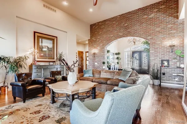 a living room with furniture a table and large windows
