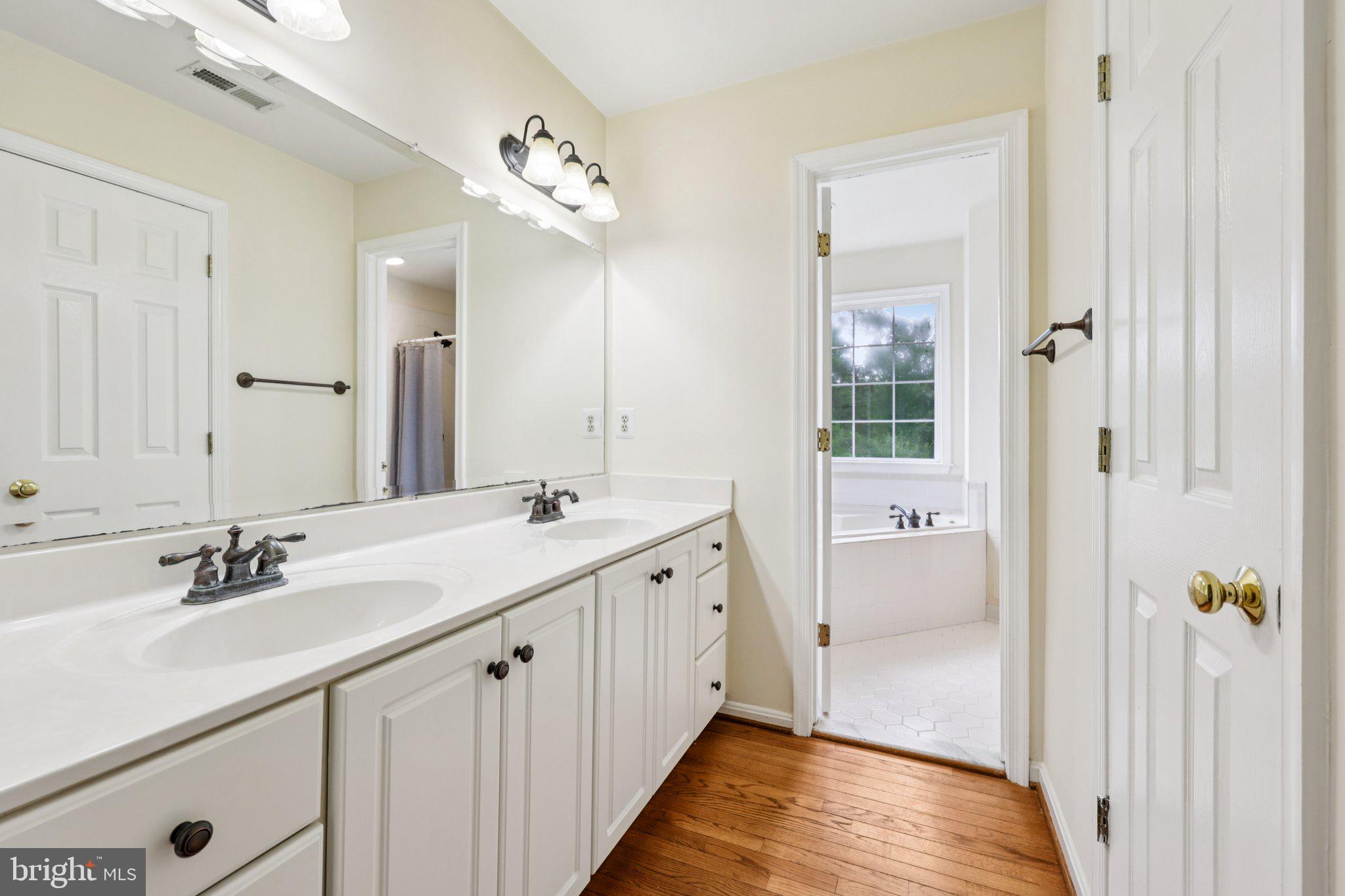 10457 Pineview Road Manassas, VA 20111 - Photo 19 of 55 a en suite bathroom with a double vanity sink a mirror and shower