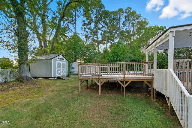 a view of a house with a yard and deck