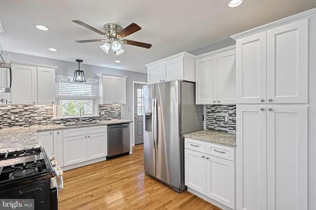 a view of a room with wooden floor and a ceiling fan