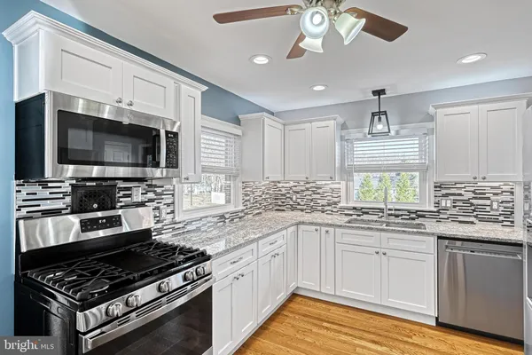 a kitchen with stainless steel appliances kitchen island granite countertop a stove and a sink