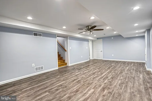a view of empty room with wooden floor