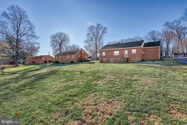 a view of a house with a big yard and large trees