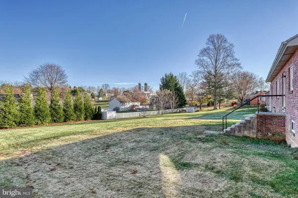 a view of a house with a yard and basketball court