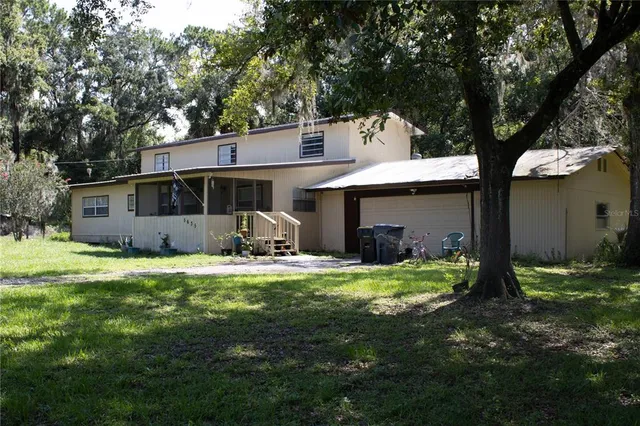 a view of a house with backyard and sitting area