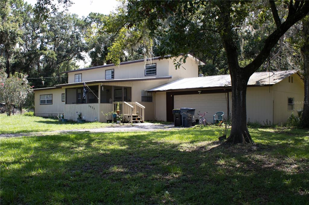 a view of a house with backyard and sitting area