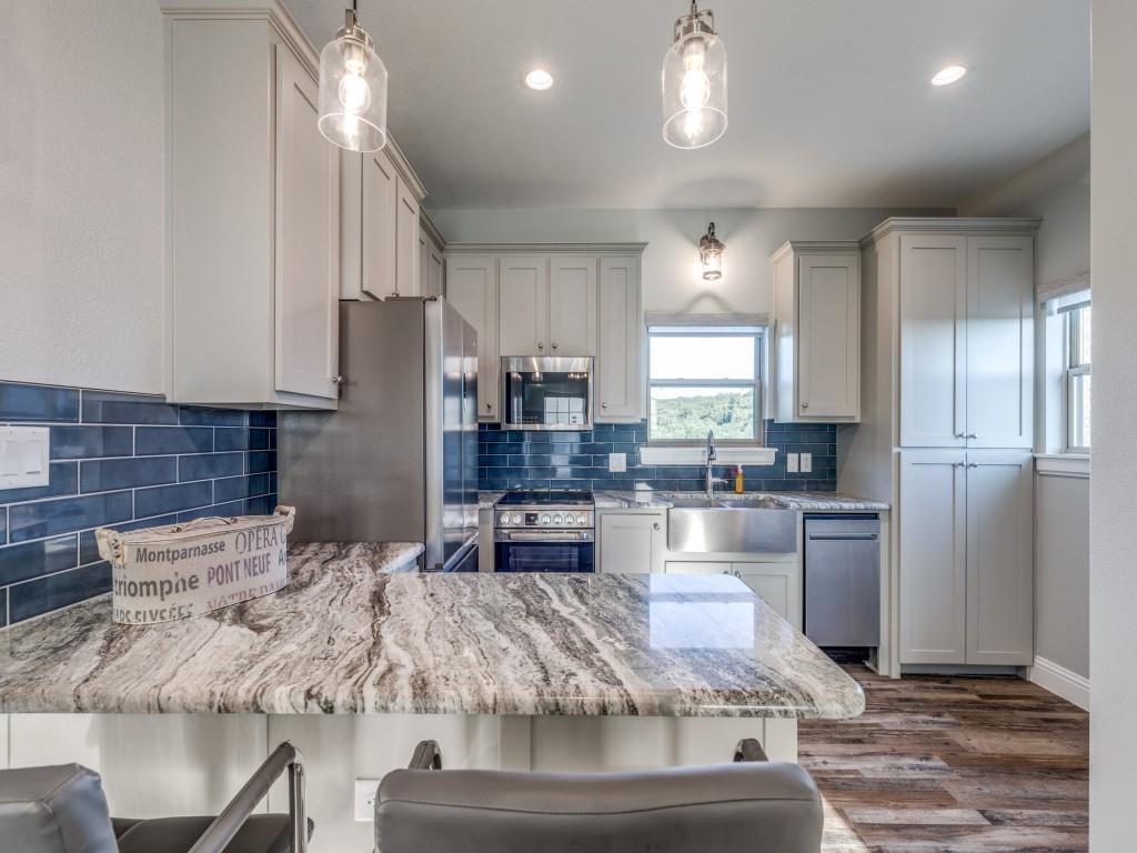165 Cote D Azur Chico, TX 76431 - Photo 30 of 40 a kitchen with kitchen island granite countertop a sink cabinets and stainless steel appliances