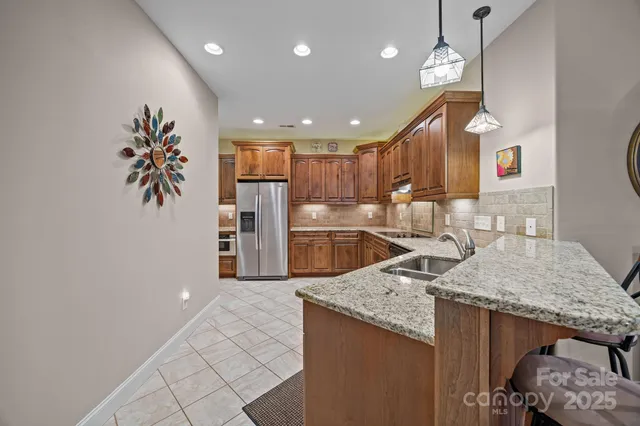a kitchen with granite countertop kitchen island a sink stainless steel appliances and a counter top space