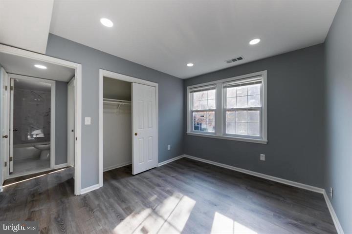 2055 38th Street Southeast, Unit 102 Washington, DC 20020 - Photo 4 of 7 an empty room with wooden floor and windows