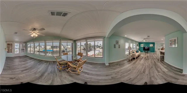 a dining room with furniture a chandelier and wooden floor