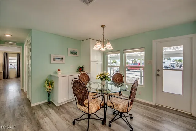 a large kitchen with granite countertop a table chairs and a chandelier