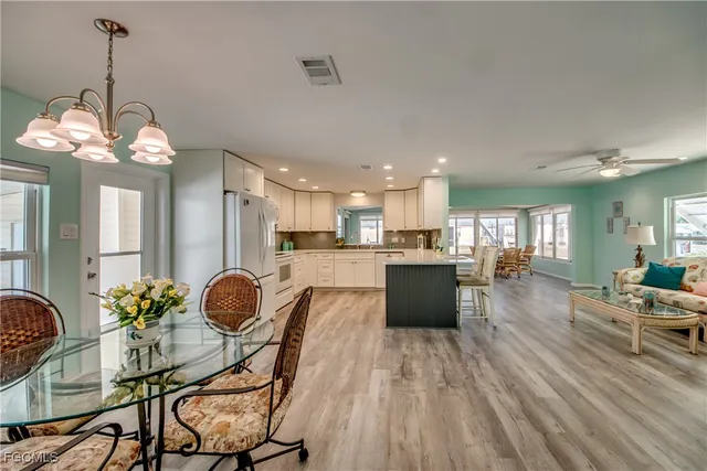 a kitchen with granite countertop a table chairs stove a refrigerator and couches