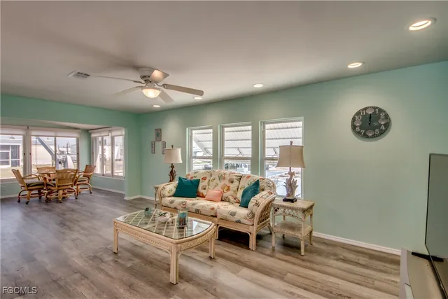 a living room with furniture kitchen view and a window