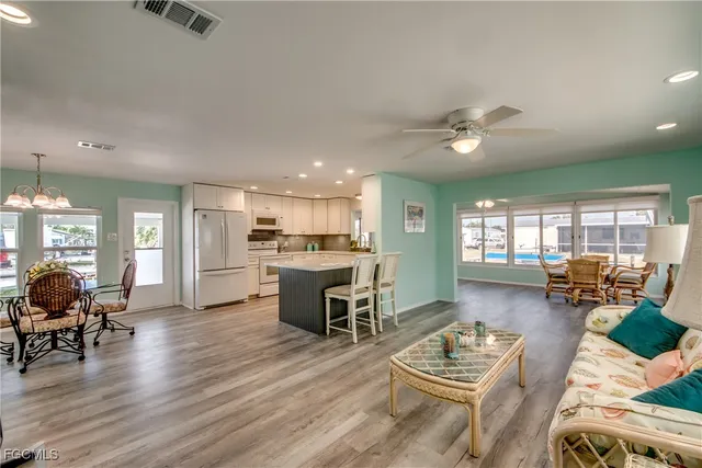 a living room with furniture a flat screen tv and a wall painting