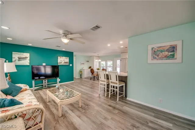 a bedroom with a large bed chandelier and a window