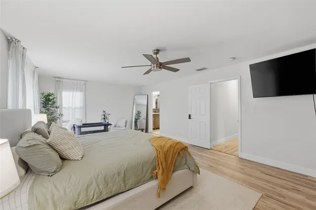 a spacious bedroom with a bed and a flat screen tv