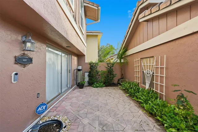 a backyard of a house with potted plants and brick wall