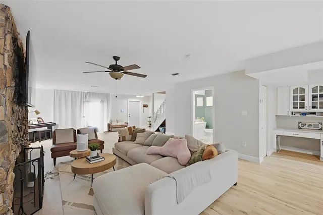 a living room with furniture kitchen view and a window