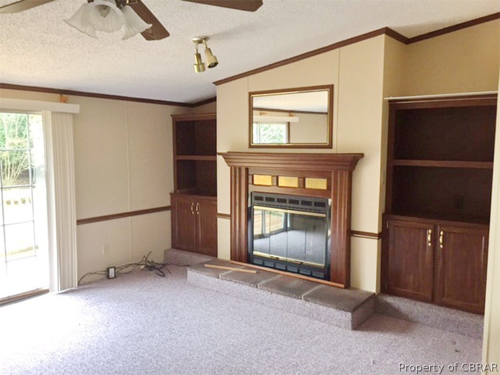 Fireplace in the den with built-in bookshelves on each side.