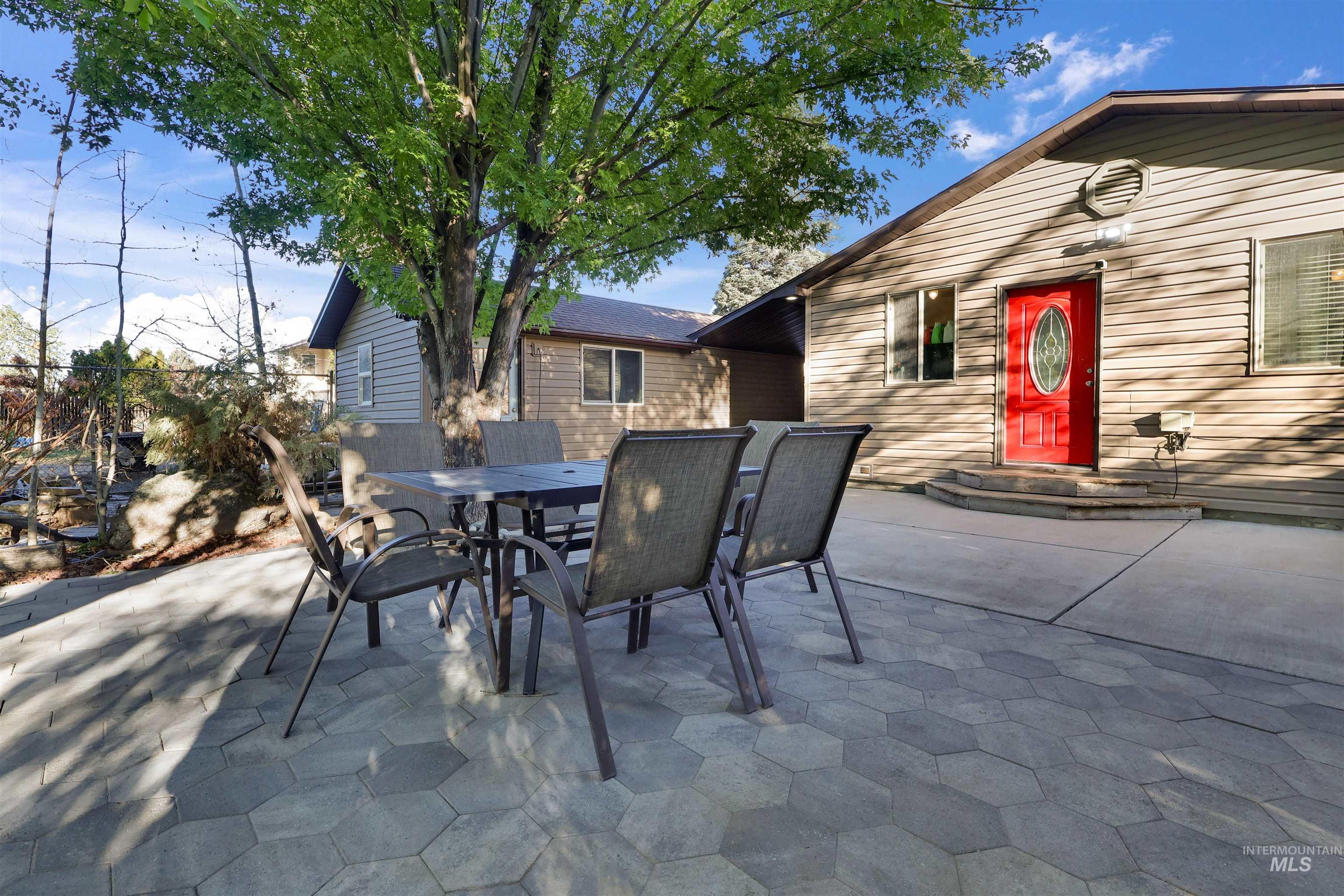1009 9th Street Rupert, ID 83350 - Photo 19 of 28 Expansive patio featuring hexagonal pavers and concrete surfacing, surrounded by mature trees