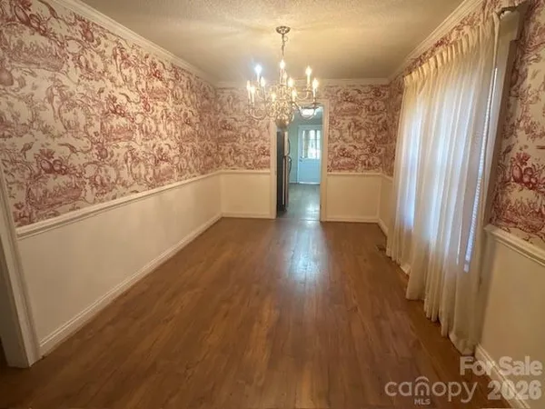 a view of a big room with wooden floor and windows